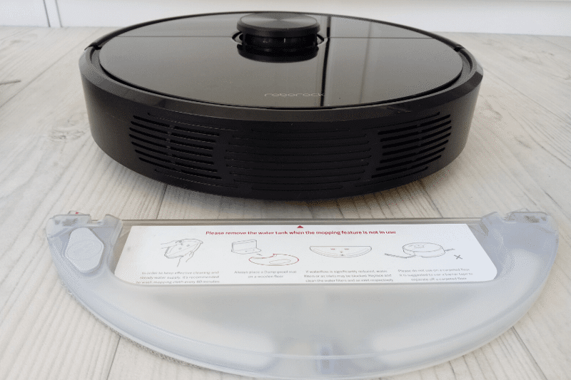 The water tank of the Roborock S6 is behind the robot vacuum.